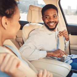 A driver and his passenger buckling their seatbelt before hitting the road.